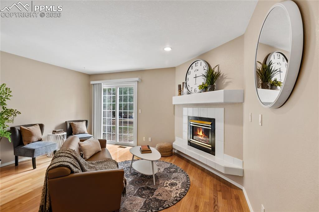 Image 8 of 37: Spacious living room with real wood flooring, gas fireplace and it walks ou