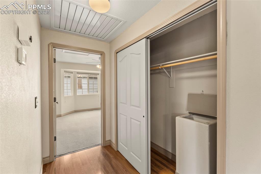 Image 14 of 34: Hallway to master showing large coat closet and attic fan. 