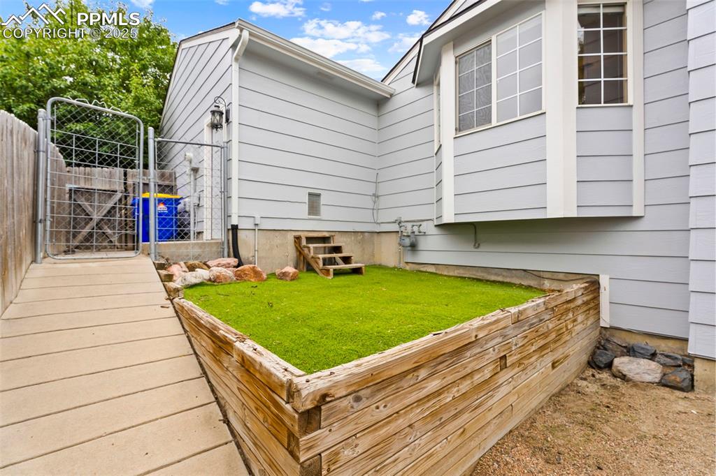 Image 27 of 34: Turfed area with pet door into garage. 