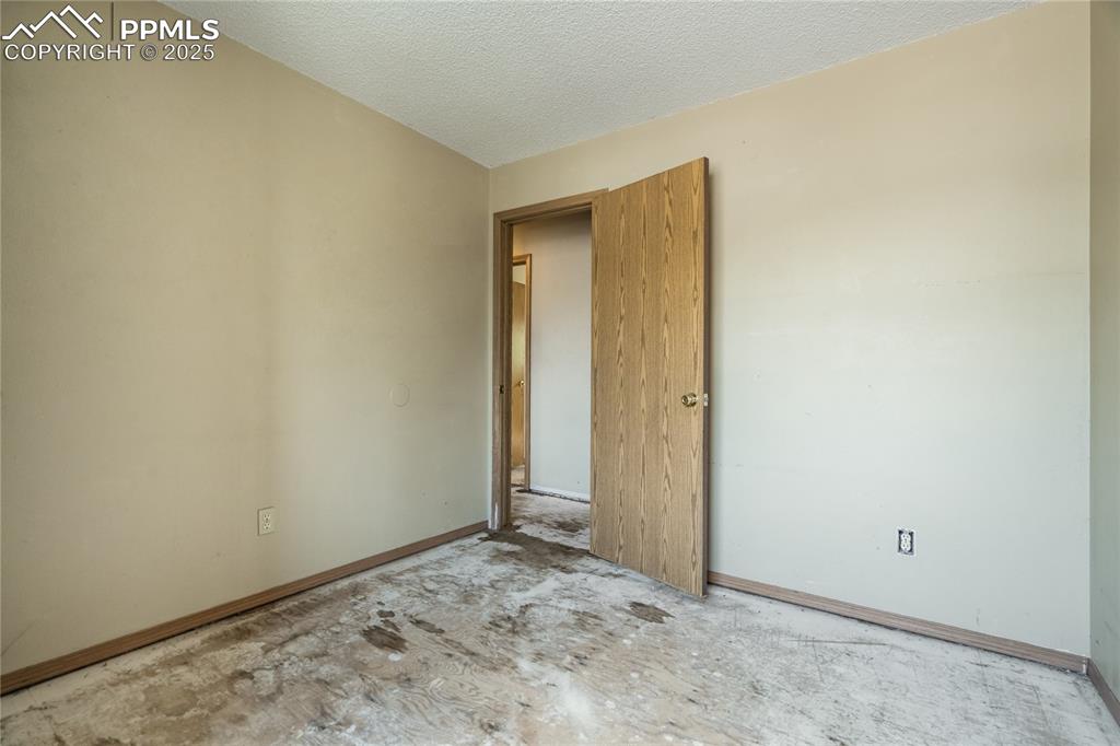 Image 13 of 24: Unfurnished bedroom featuring a textured ceiling and baseboards