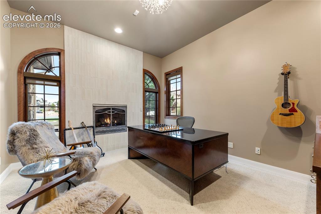 Image 16 of 36: Office with gas fire place and built-in cabinets