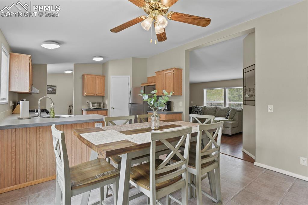 Image 10 of 37: Dining space featuring light tile patterned floors and a ceiling fan