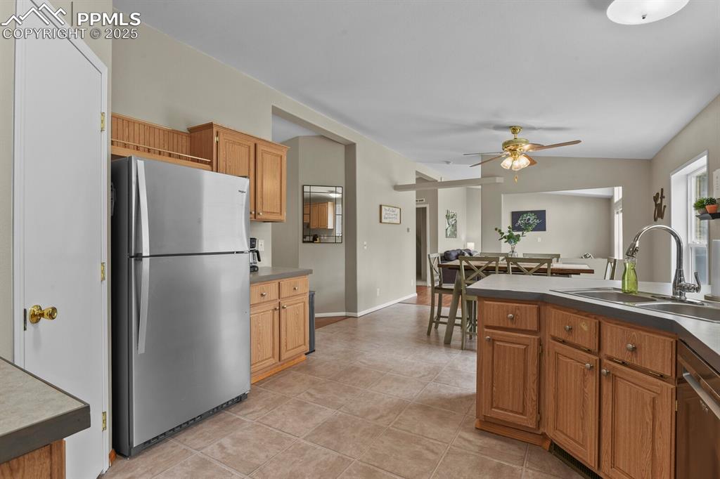 Image 12 of 37: Kitchen with stainless steel appliances, vaulted ceiling, a ceiling fan, br
