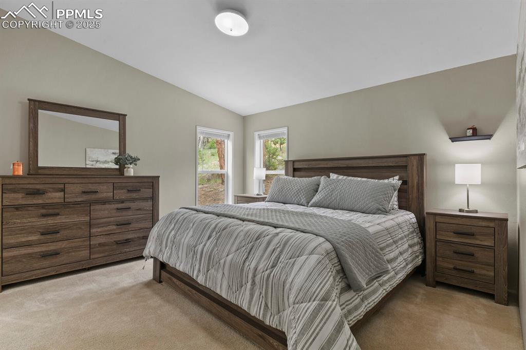 Image 14 of 37: Bedroom with carpet floors and lofted ceiling