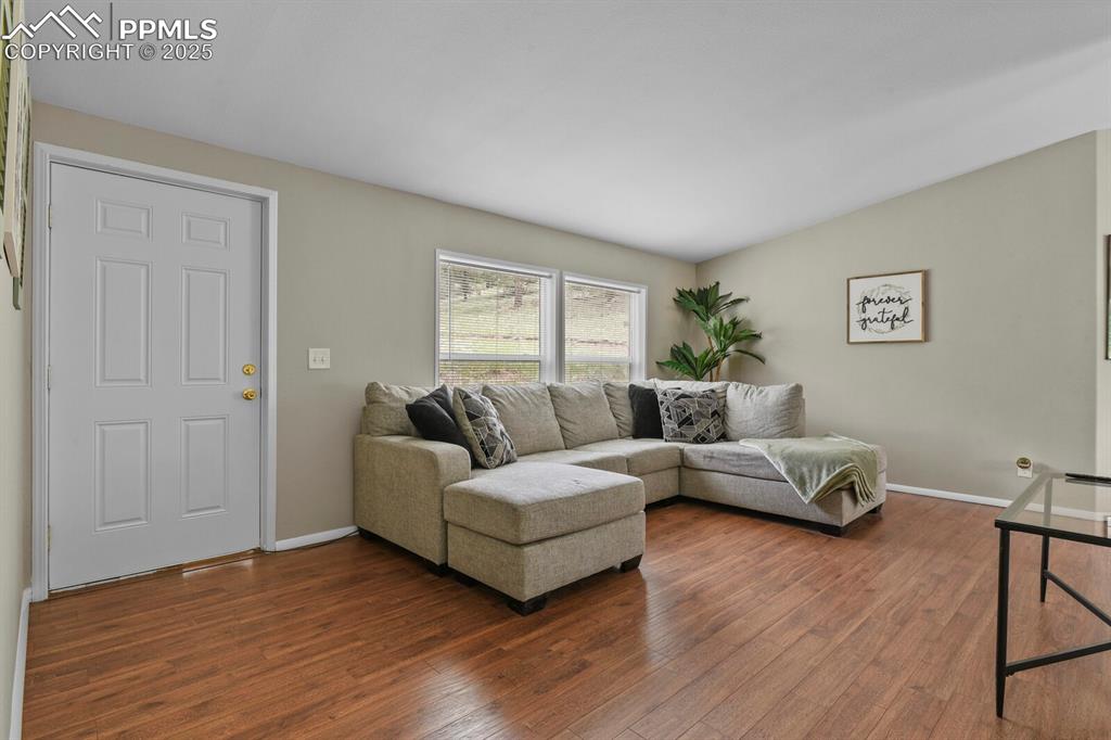 Image 2 of 37: Living room with dark wood finished floors and lofted ceiling