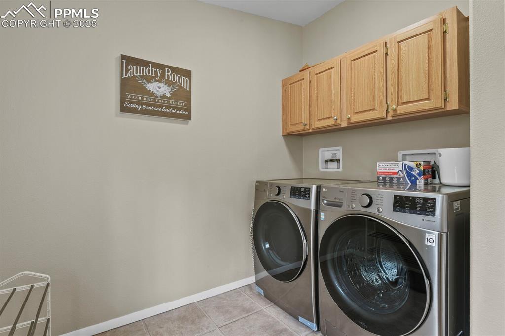 Image 23 of 37: Washroom featuring light tile patterned flooring, washer and dryer, and cab