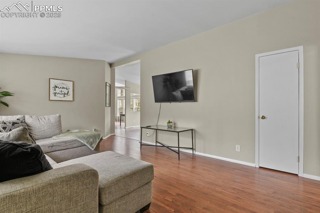 Image 3 of 37: Living room with dark wood-type flooring and vaulted ceiling