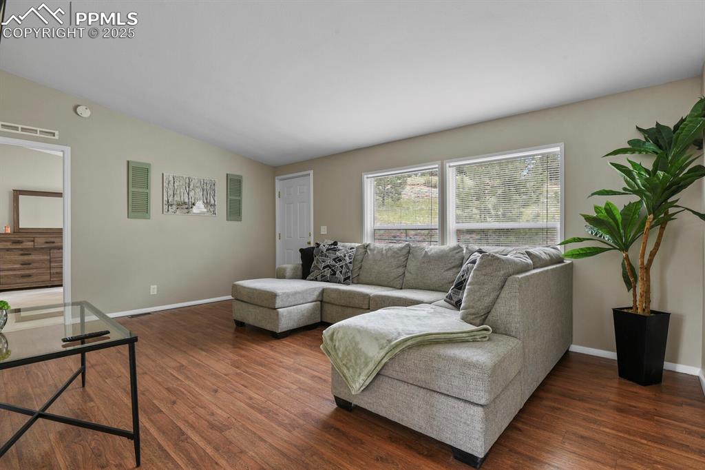 Image 4 of 37: Living area featuring dark wood finished floors and lofted ceiling