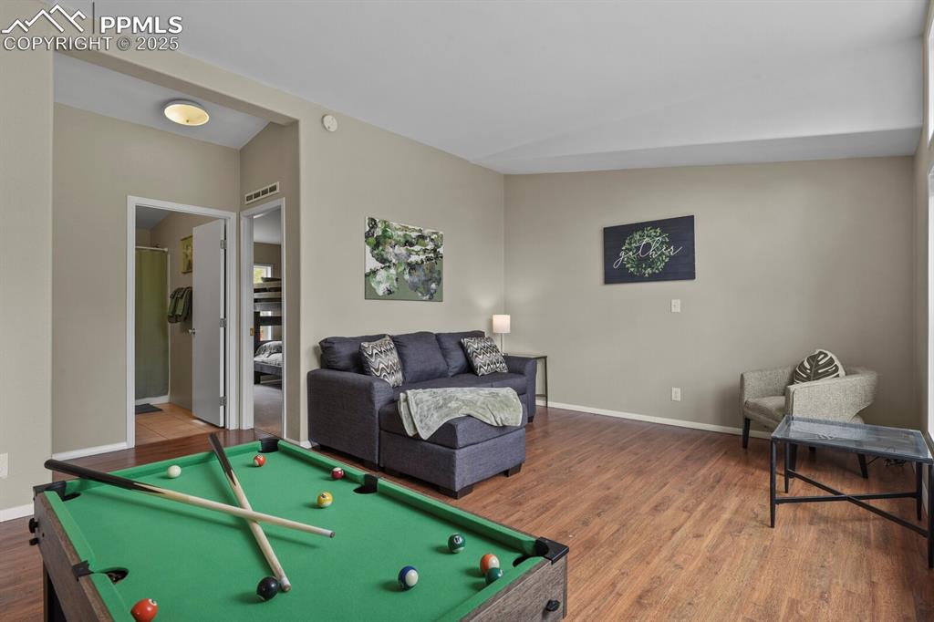 Image 8 of 37: Rec room featuring pool table, wood finished floors, and lofted ceiling