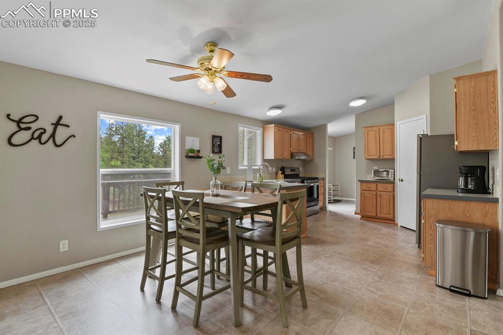 Image 9 of 37: Dining room featuring light tile patterned flooring and ceiling fan