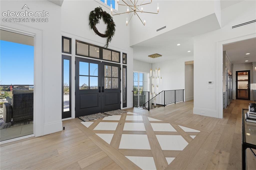 Image 10 of 50: Grand foyer featuring high ceilings, double entry doors with glass panes, w