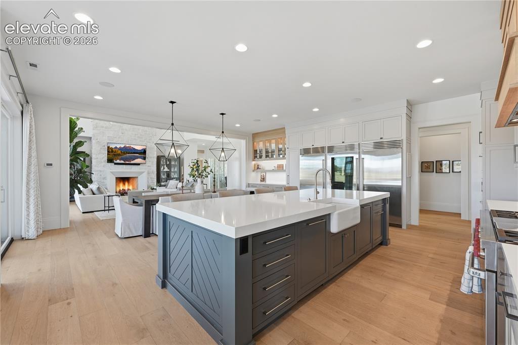 Image 17 of 50: Kitchen featuring a large central island with quartz countertops, custom ca