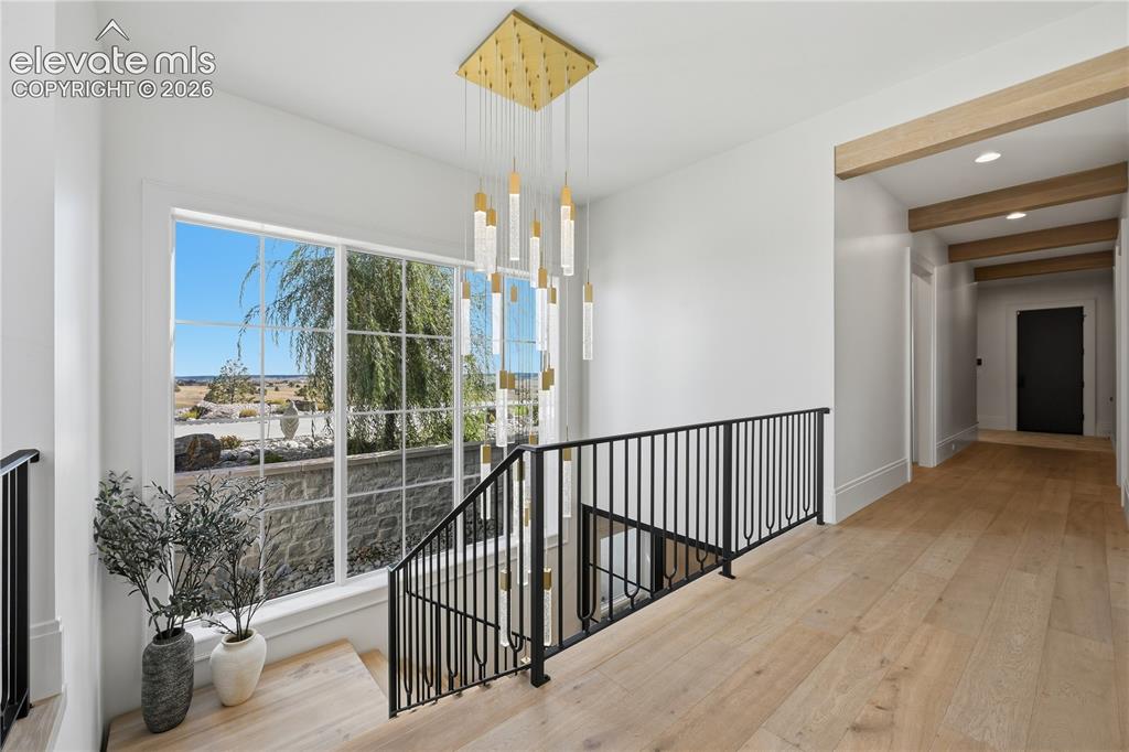 Image 20 of 50: Multi-level foyer featuring wood-finish flooring, a tiered gold-finish chan