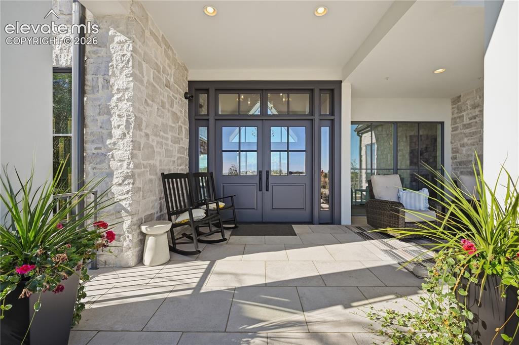 Image 21 of 50: Covered entryway featuring natural stone wall cladding, large-format stone