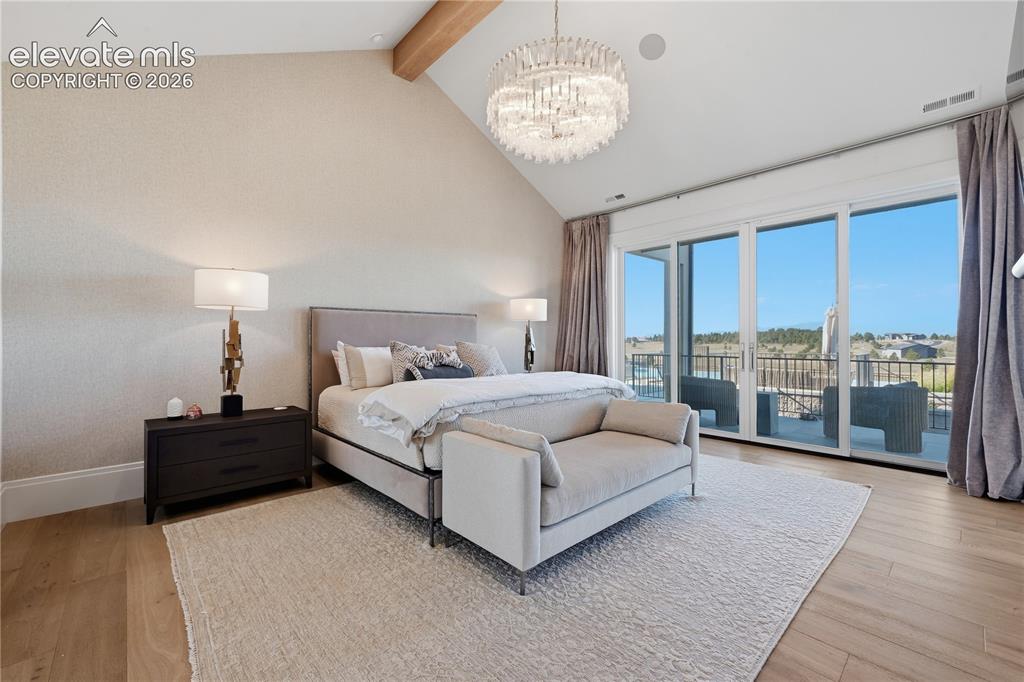 Image 23 of 50: Vaulted ceilings with decorative wood-finish beam, expansive floor-to-ceili