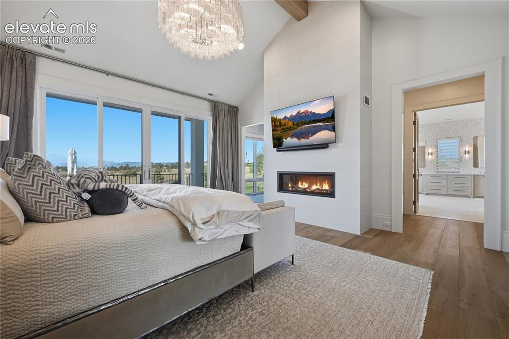 Image 26 of 50: Vaulted ceiling with exposed beam, linear fireplace, floor-to-ceiling large