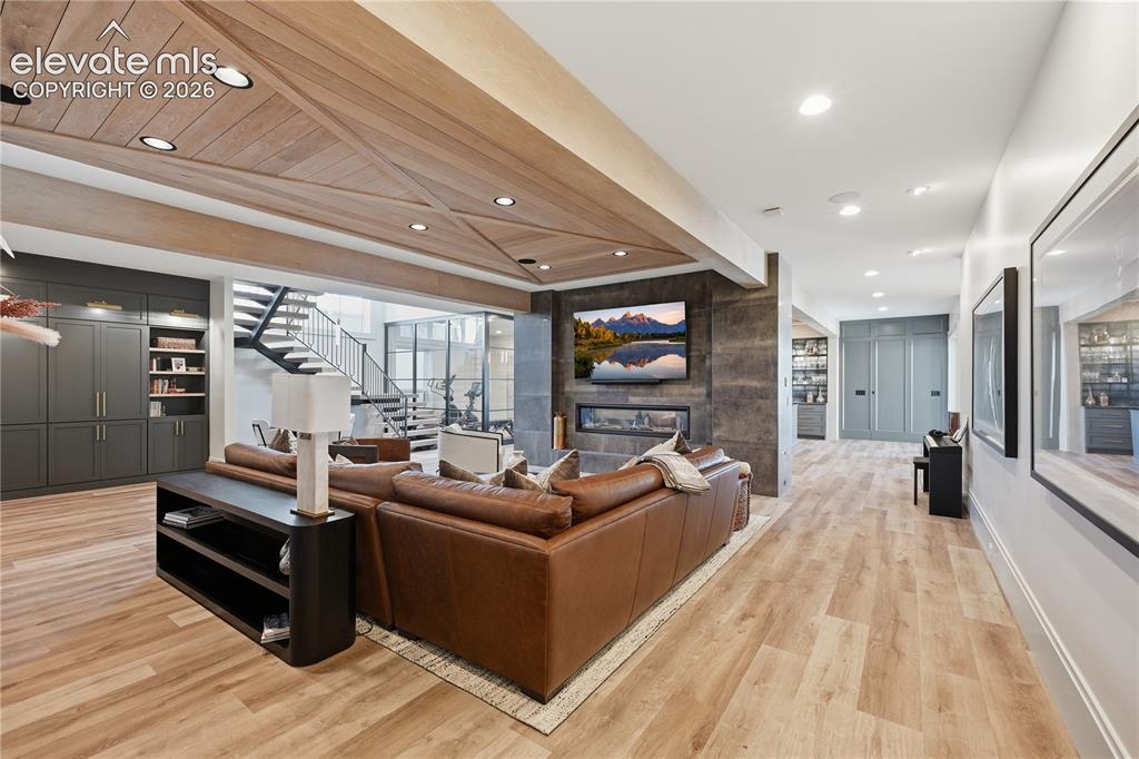 Image 31 of 50: Living space featuring a wood-plank ceiling with decorative beam inlay, a f