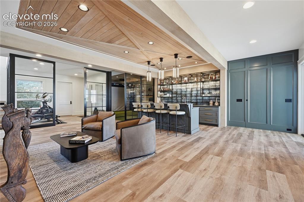 Image 32 of 50: Custom wood-paneled ceiling feature with recessed lighting, integrated wet 