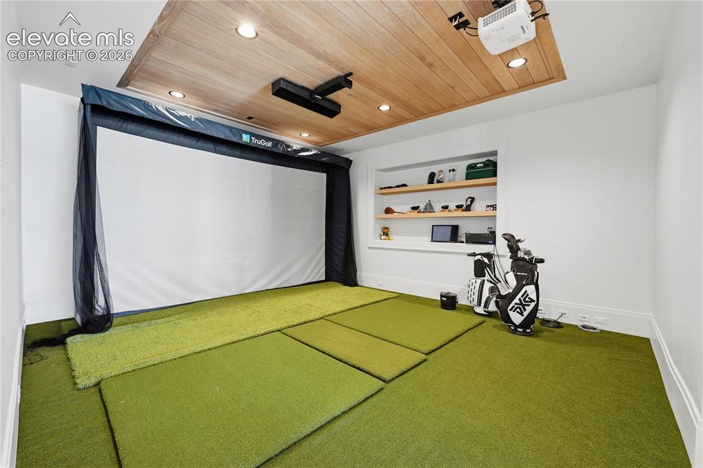 Image 33 of 50: Dedicated simulation room featuring a wood-plank recessed ceiling, inset sh