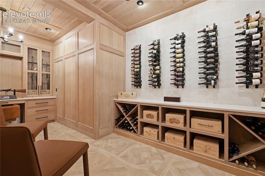 Image 35 of 50: Custom wine cellar featuring extensive light wood millwork, coffered wood-p