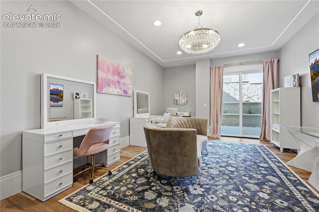 Image 36 of 50: Tray ceiling with recessed lighting, crystal chandelier, wood-finish floori
