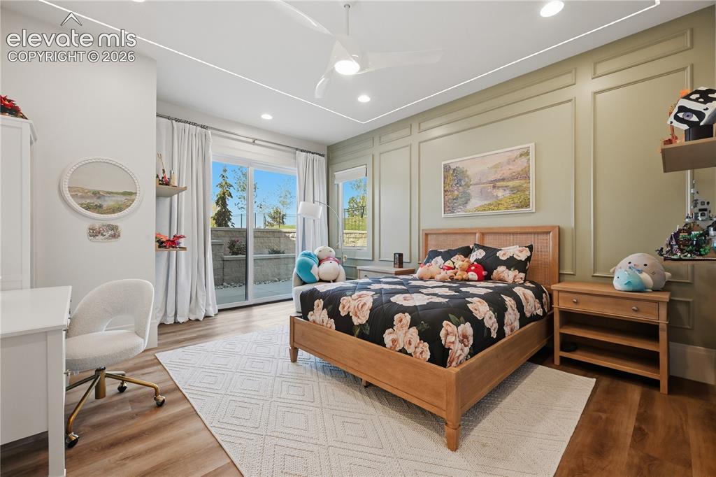 Image 37 of 50: Bedroom featuring wall-applied decorative molding, wood-finish flooring, re