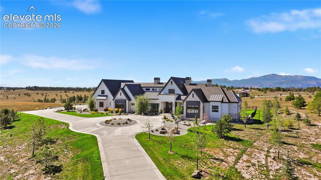 Image 4 of 50: Custom estate featuring a multi-gabled roofline, light-colored exterior fin