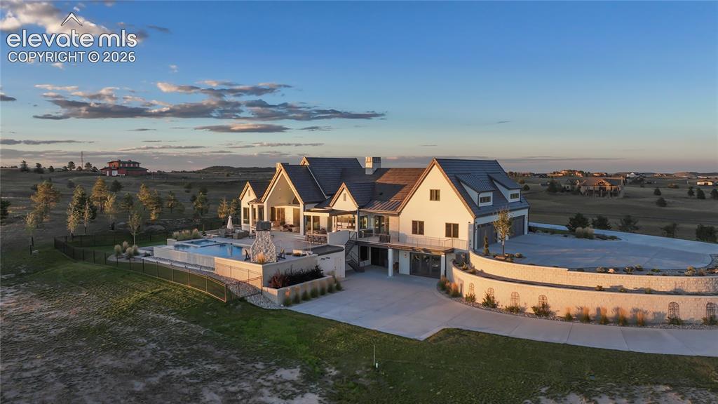 Image 41 of 50: Multi-gabled estate featuring a concrete driveway, retaining walls with sto