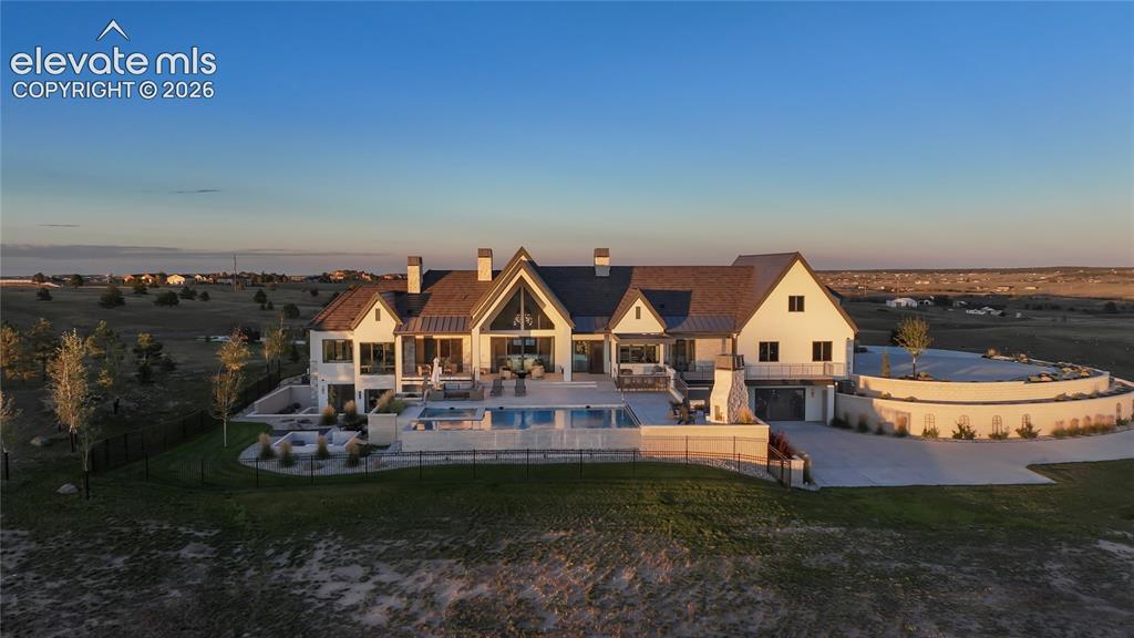 Image 42 of 50: Custom estate featuring light-toned exterior siding, a multi-gabled rooflin