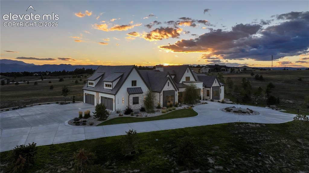Image 44 of 50: Multi-gabled exterior featuring stone and stucco siding, a tiled roof, mult