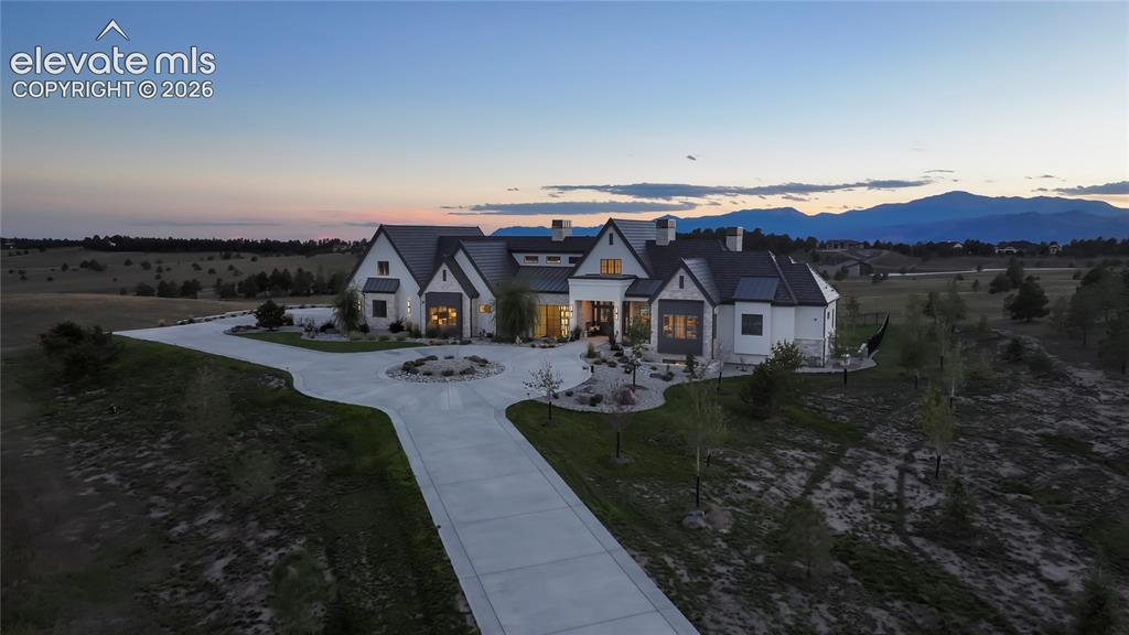 Image 48 of 50: Custom multi-gabled residence featuring a stone and siding exterior, metal 