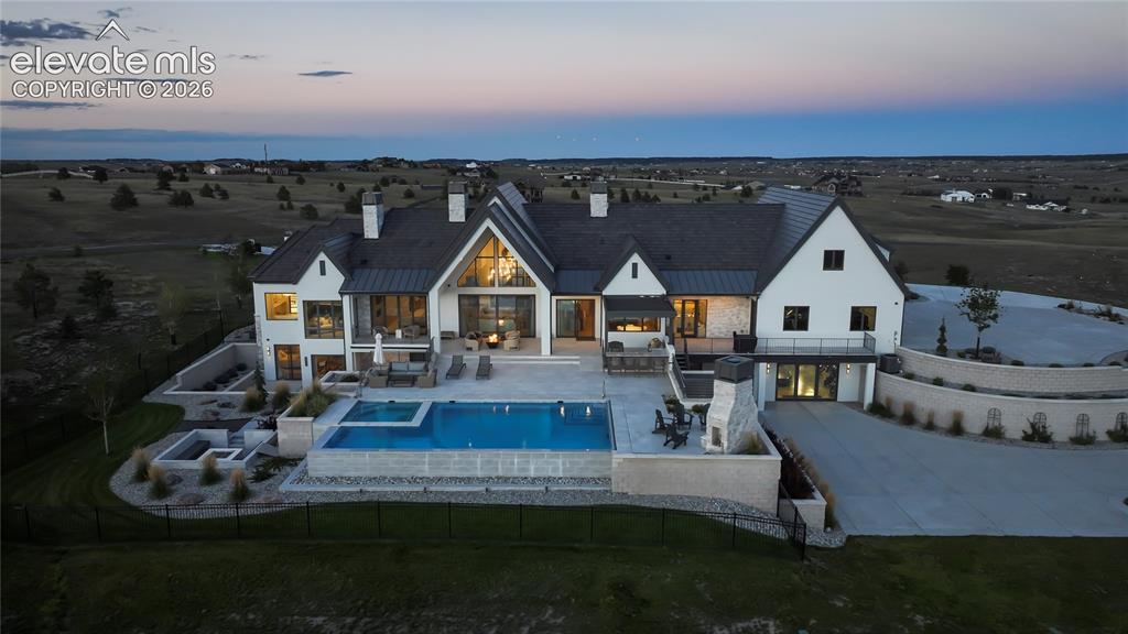 Image 49 of 50: Multi-level exterior featuring a stone and siding facade, an infinity-edge