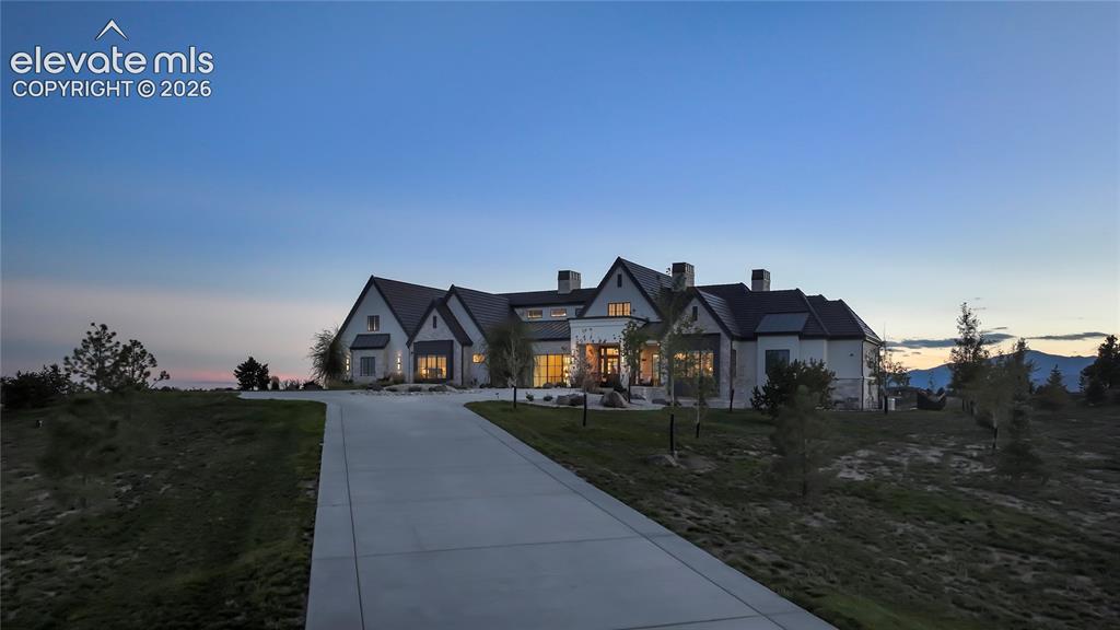 Image 50 of 50: Custom estate featuring light-toned masonry exterior, multi-gabled roofline