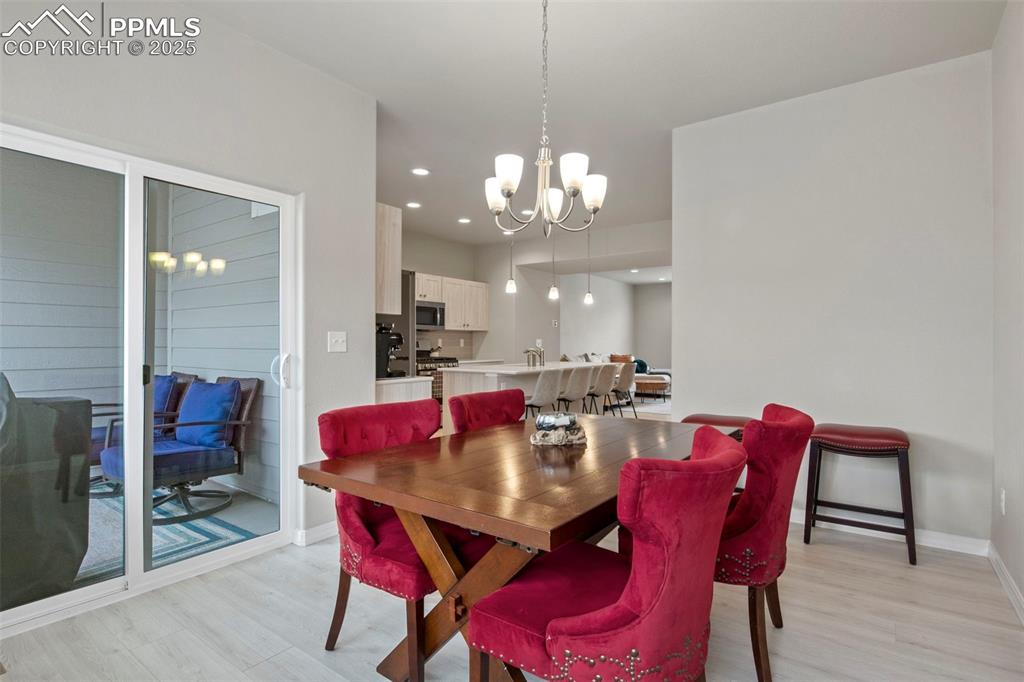 Image 18 of 34: Dining area featuring light wood-style flooring, a notable chandelier, base