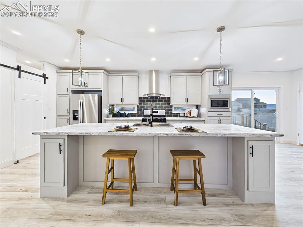 Image 11 of 50: Spacious gourmet kitchen featuring a large center island, stainless steel a