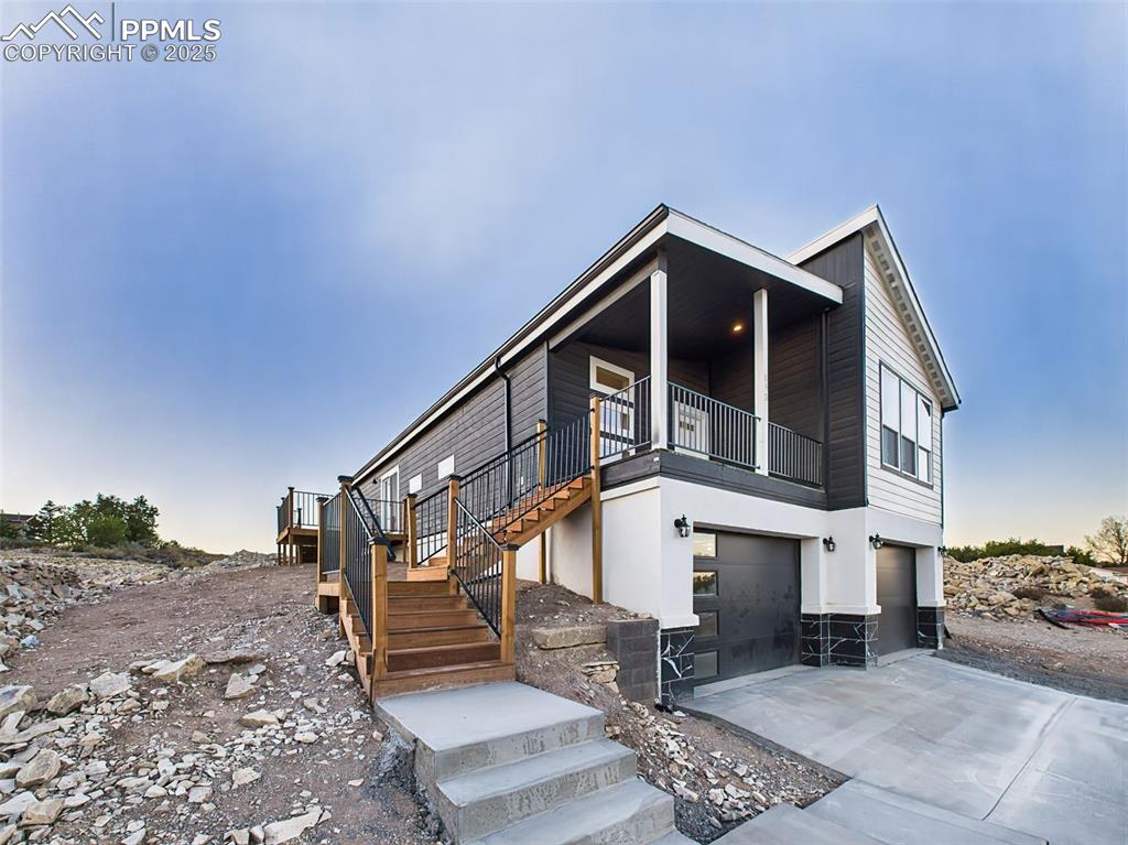Image 2 of 50: Daytime view of the home highlighting the elevated lot, fresh landscaping p