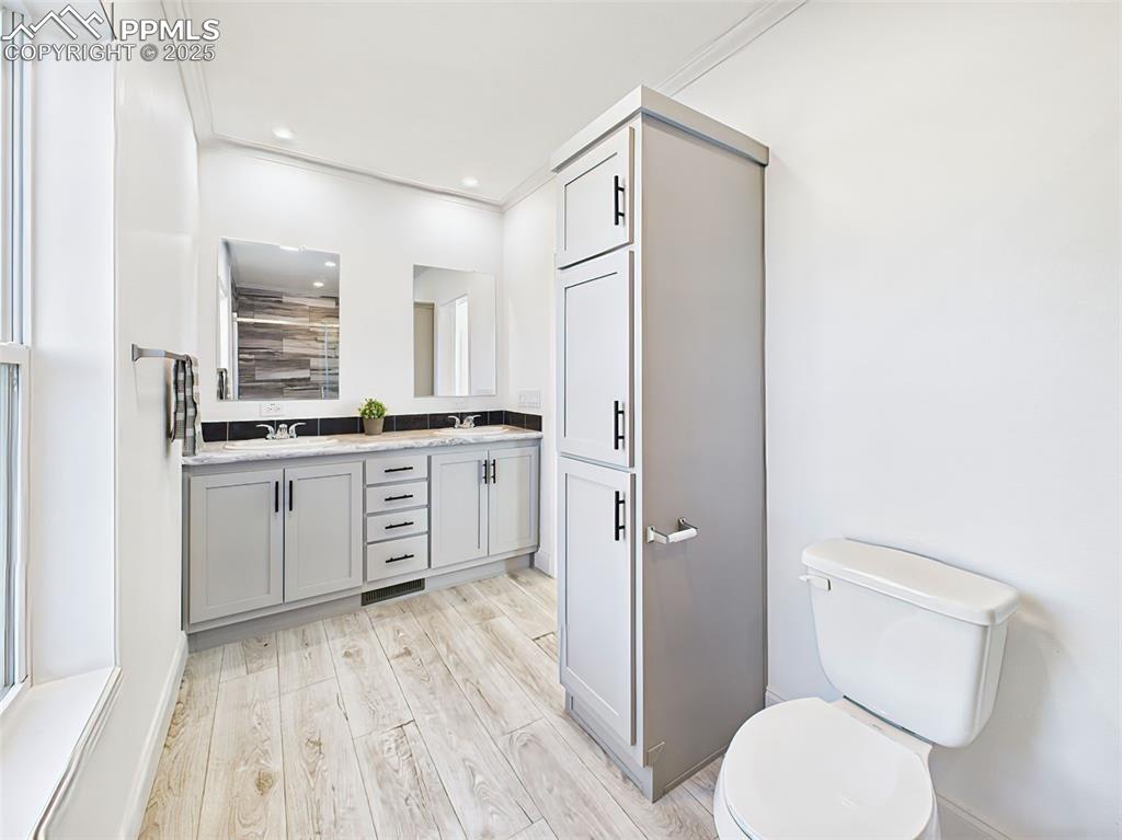 Image 30 of 50: Bright primary bath with modern finishes, large mirror, and high ceilings.