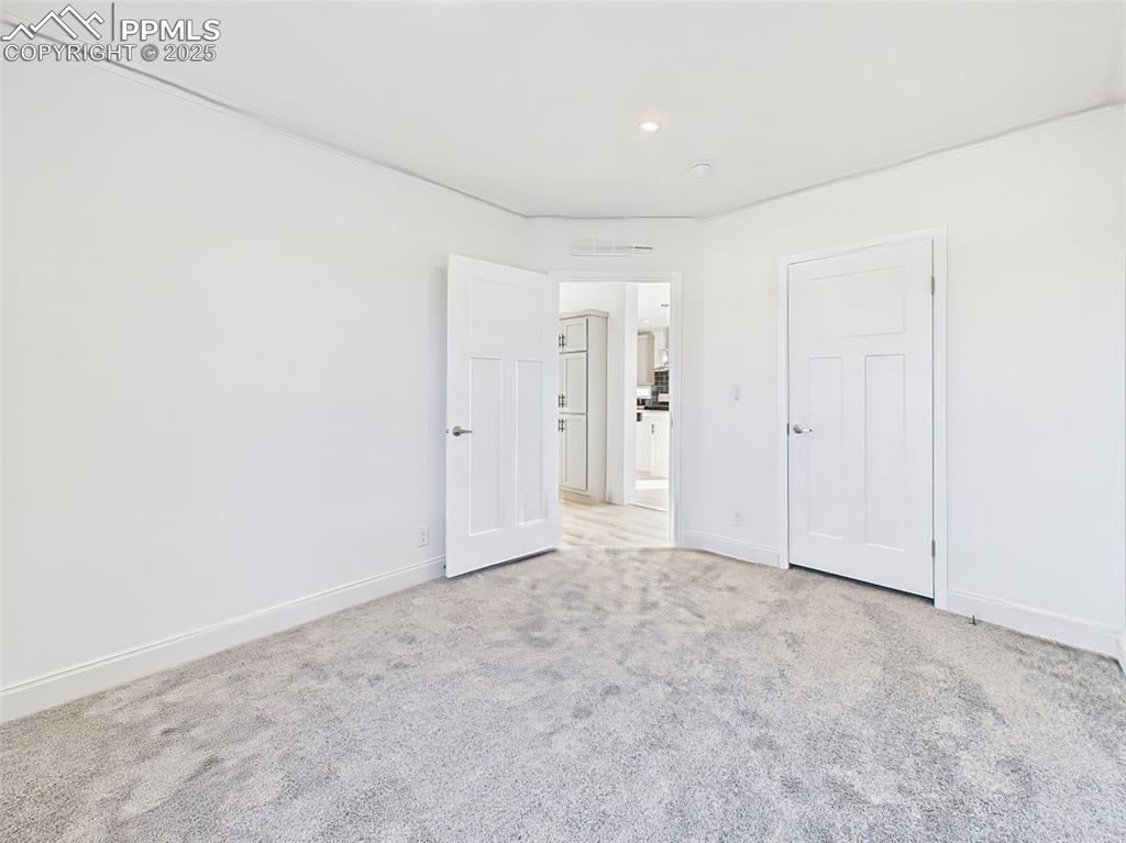 Image 34 of 50: Un staged version bedroom 2 showing clean layout, fresh paint, and natural
