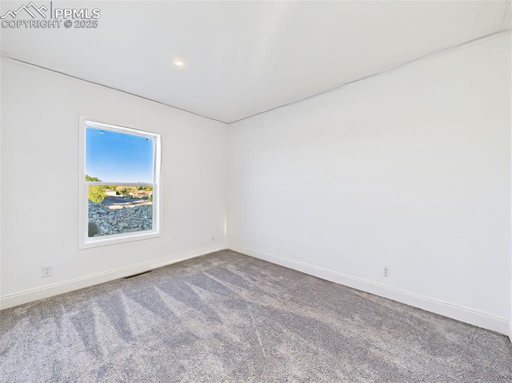 Image 36 of 50: Unstaged version bedroom 3 highlighting new carpet, recessed lighting, and