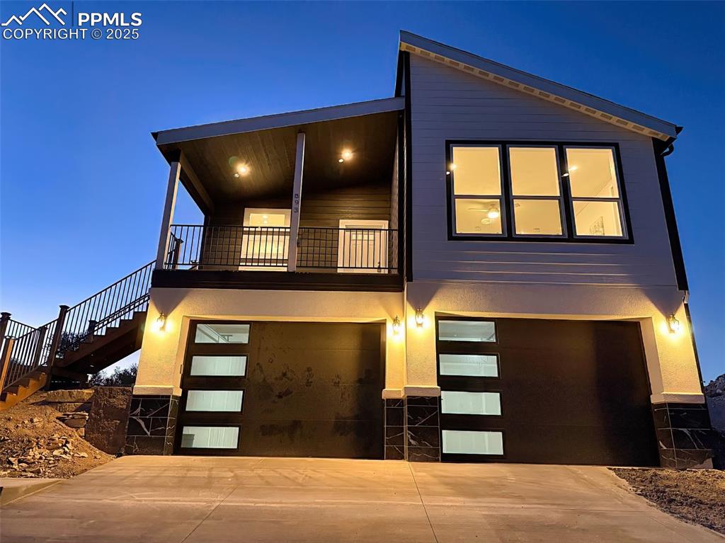 Image 42 of 50: Evening view showcasing designer lighting and curb appeal.