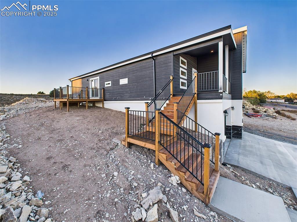 Image 49 of 50: Exterior stairs and dual decks with black railings and wood accents leading