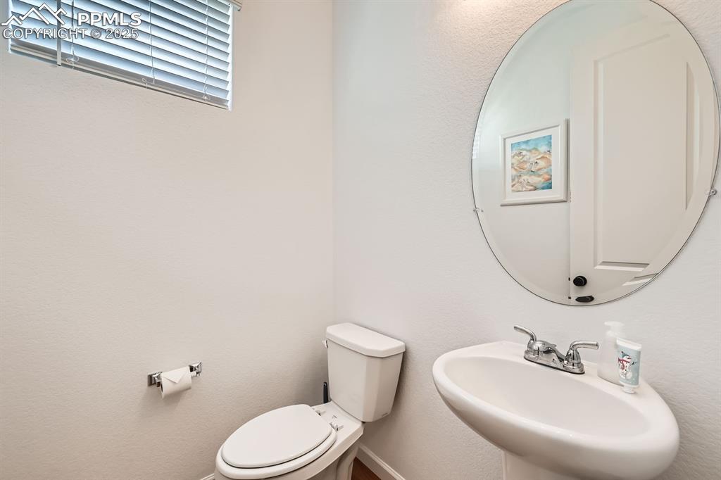 Image 16 of 28: Half bathroom with a sink and toilet