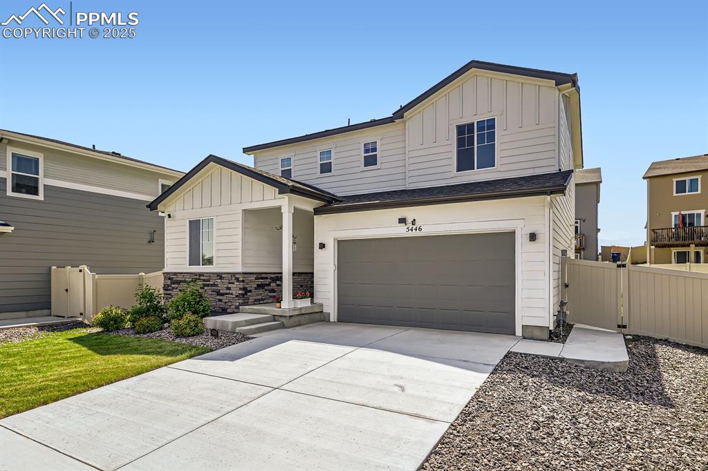 Image 3 of 28: View of front of home with board and batten siding, an attached garage, and
