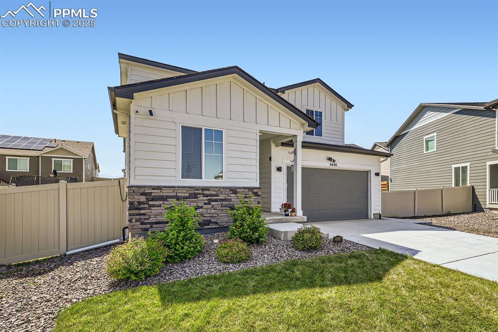 Image 4 of 28: View of front facade featuring concrete driveway, board and batten siding, 