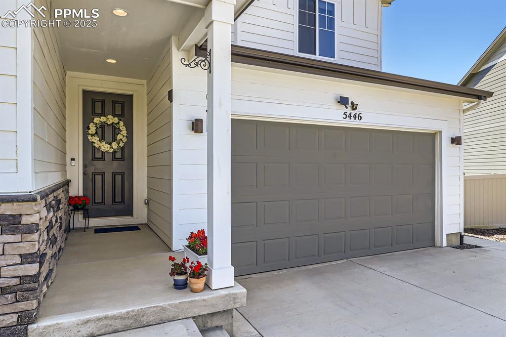 Image 5 of 28: Property entrance with a garage and driveway
