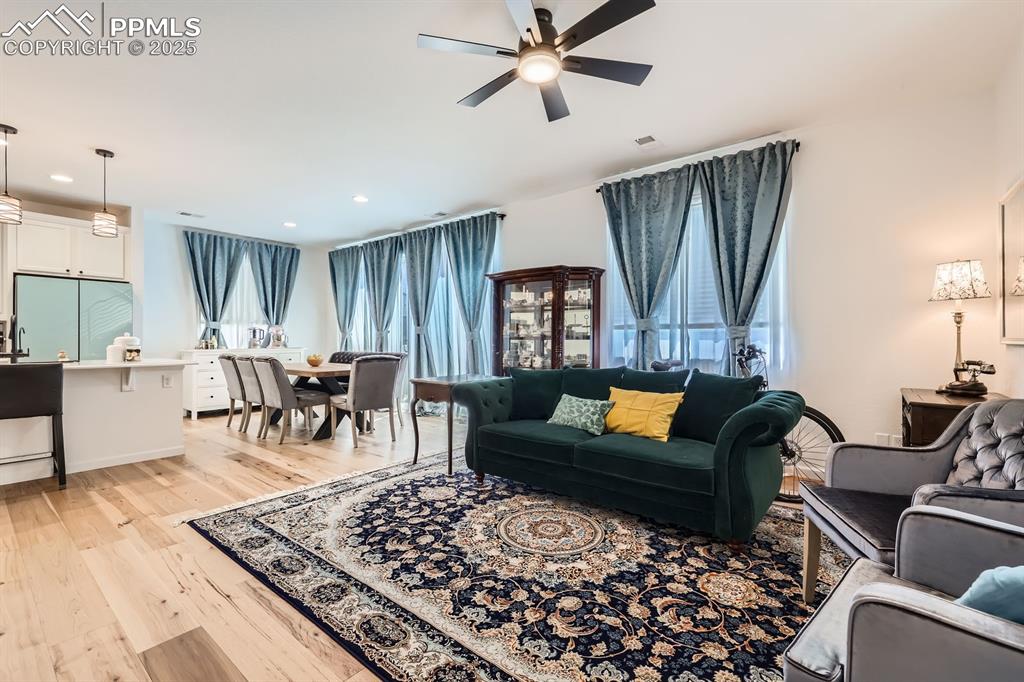 Image 9 of 28: Living area with ceiling fan, light wood-style flooring, healthy amount of 
