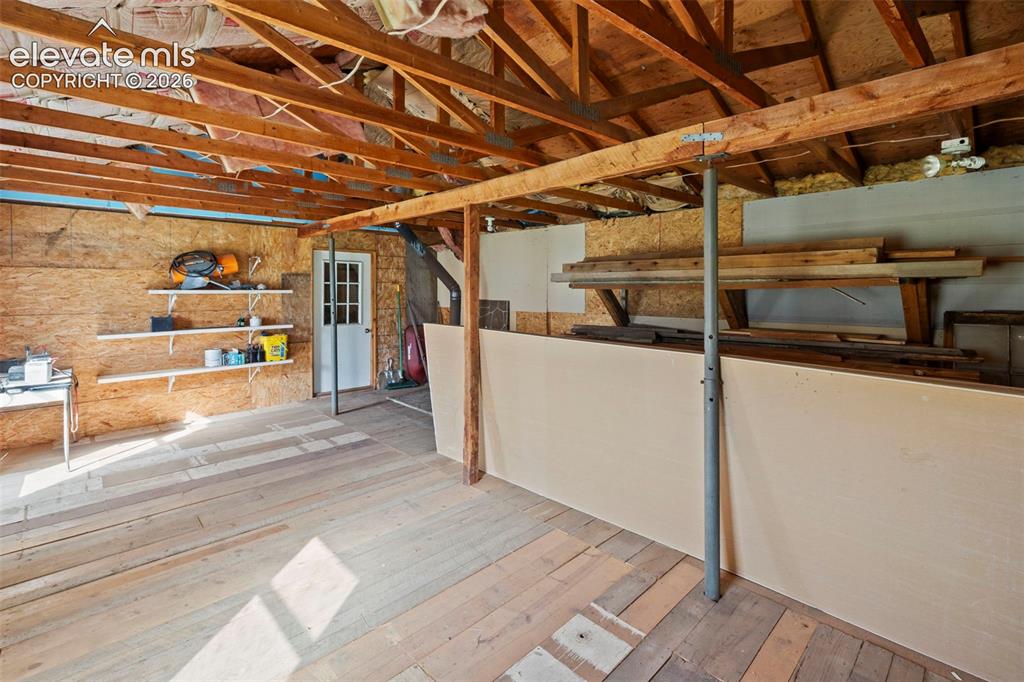 Image 39 of 50: Carport, stalls, storage off rear of barn. 