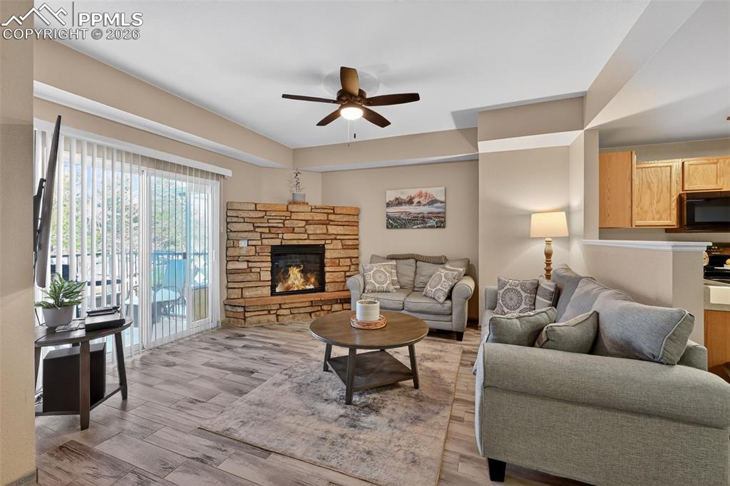 Image 3 of 21: Cozy living room with gas fireplace and sliding glass door. 