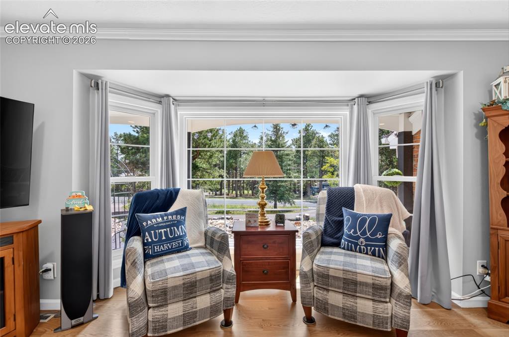 Image 10 of 43: Expansive bay window with multiple panes, crown molding, light-toned walls,