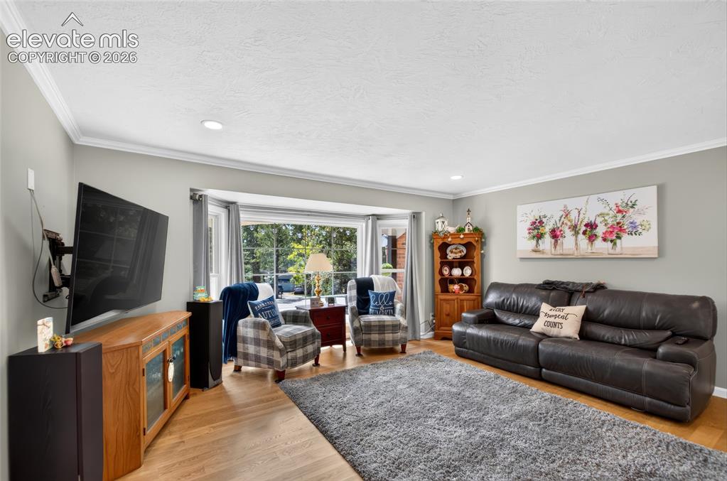 Image 11 of 43: Hardwood flooring, recessed ceiling lighting, crown molding, bay window, an